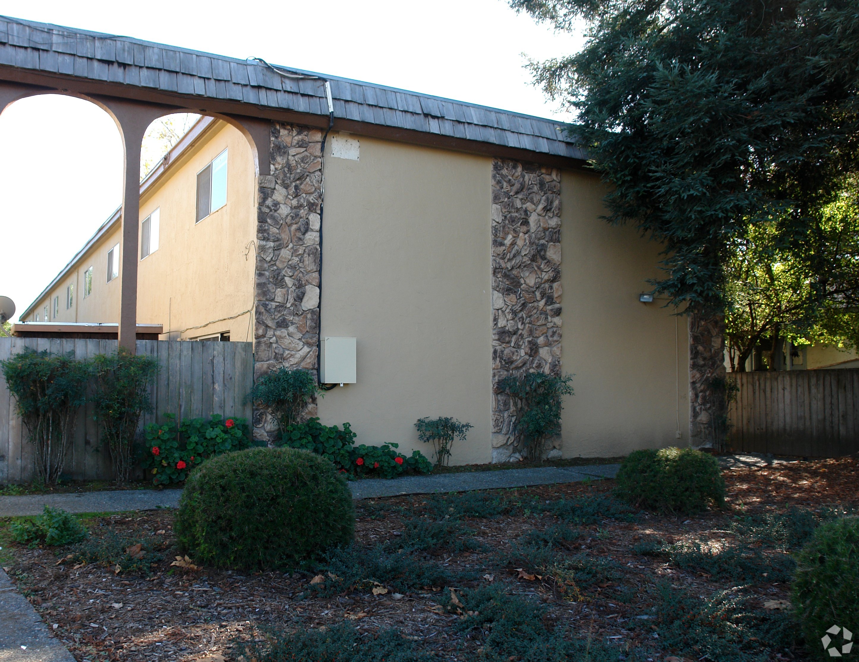 A house with a stone wall and a wooden fence.